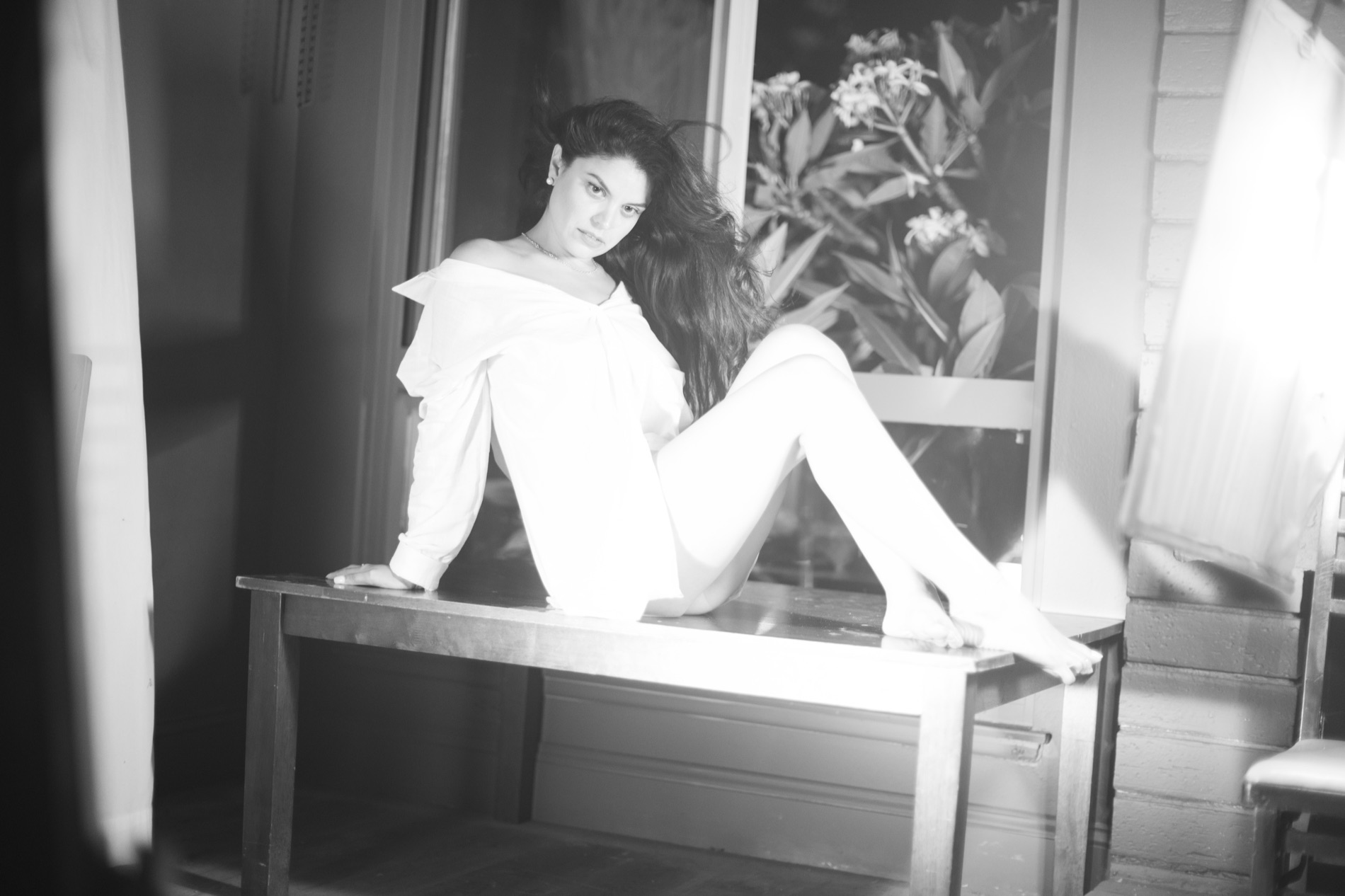 Kimberly posed across a ledge in a monochrome fashion portrait
